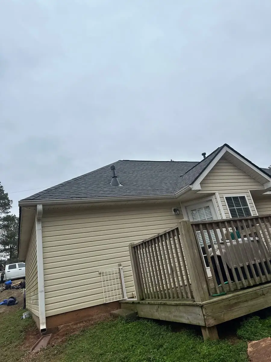 Shingle roof on the back of a home with a wooden deck in Grantville, GA
