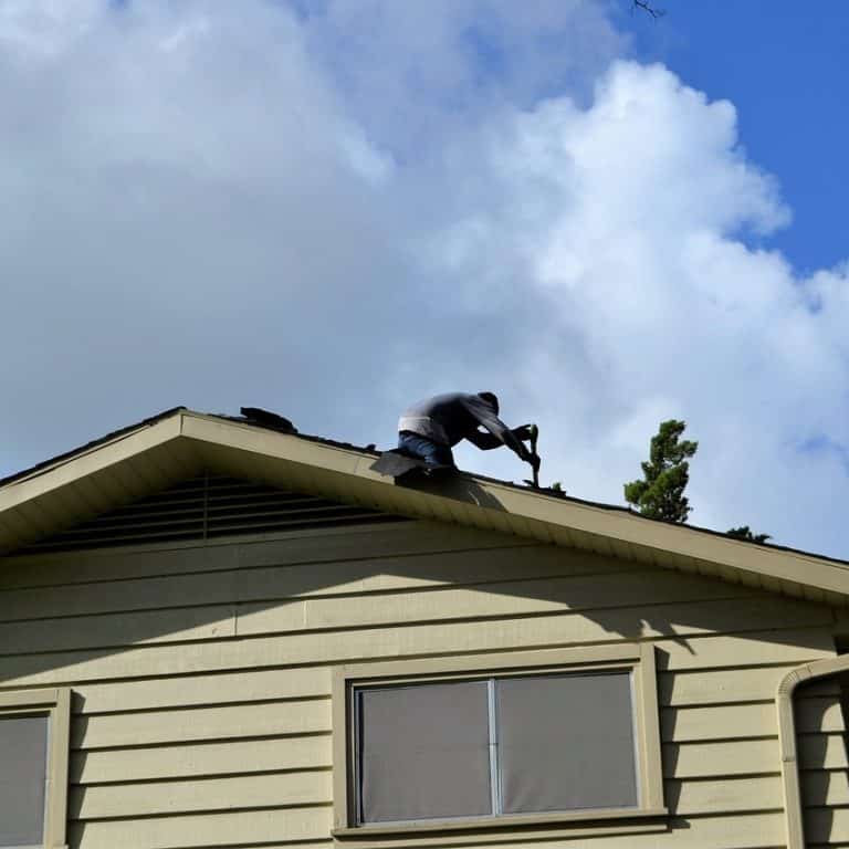 Roofing contractor replacing shingles.